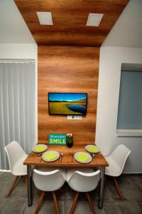 a dining room with a wooden table and white chairs at Lakefive Apartments Balatonfüred in Balatonfüred