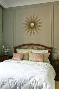 a bedroom with a white bed with a clock on the wall at Altbauwohnung im Herzen von Karlsruhe in Karlsruhe +64 photos