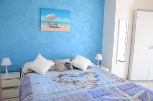 ein blaues Schlafzimmer mit einem Bett mit einer Katze auf dem Bett in der Unterkunft Santanna Beach House - Fondachello-apartments com in Mascali