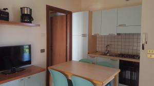 eine Küche mit einem Holztisch und blauen Stühlen in der Unterkunft Appartamenti Chemasi in Brenzone sul Garda
