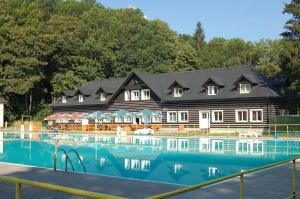 a large house with a swimming pool in front of it at Hotel Stará Ameryka in Jablunkov
