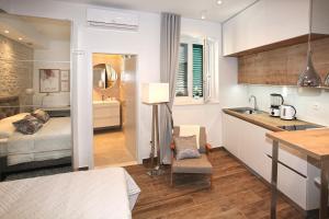 uma cozinha e um quarto com uma cama e um lavatório em Apartments Tessera em Split