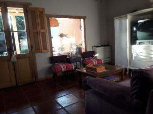 een woonkamer met een bank, een tafel en een tv bij La biblioteca in Olavarría