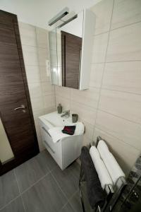 a bathroom with a sink and a mirror and towels at Lakefive Apartments Balatonfüred in Balatonfüred +40 photos