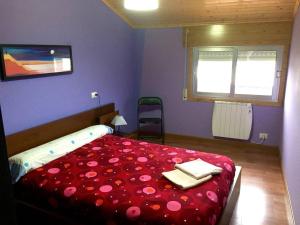1 Schlafzimmer mit einem Bett mit roter Bettwäsche und 2 Handtüchern in der Unterkunft Apart. cerca de Playa Catedrales in Lourenzá
