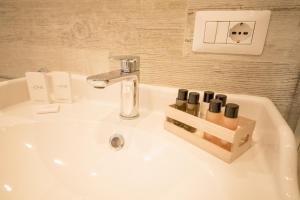 a bathroom sink with a wooden holder with wine bottles at BePlace Aventino in Rome