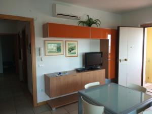 a living room with a tv and a glass table at villa a mare in Senigallia