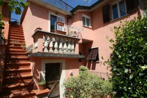 Casa de color rosa con balcón y escaleras en Ca' Rossi, en Beverino