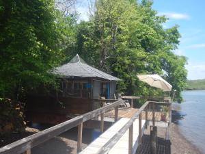 a small building on a dock with an umbrella at Beached Bungalow Overlooking the Pacific Ocean in Boca Chica