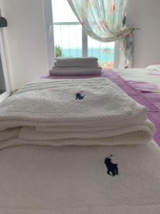 two cats on a white blanket on a bed at Urban Apartment in Petrovac na Moru