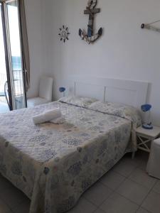 a bedroom with a bed with a comforter on it at Casa Barbara in Marzamemi