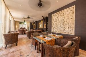 a restaurant with tables and chairs and a wall with a picture at Casa Harb Hotel Boutique in San Andrés +78 photos