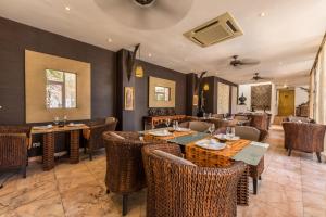 a restaurant with wicker chairs and tables in a room at Casa Harb Hotel Boutique in San Andrés