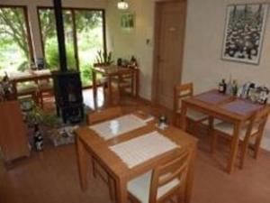 uma sala de estar com mesas e cadeiras de madeira em Guesthouse Mintaro Hut em Yamagata