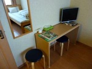 Habitación con escritorio, ordenador y espejo. en Guesthouse Mintaro Hut, en Yamagata