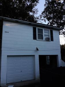 a white house with a garage door and a window at 3864 Walsh Street Apartment in Jacksonville