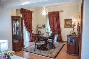 a dining room with a table and chairs and a chandelier at Villa Virginia in Vonitsa