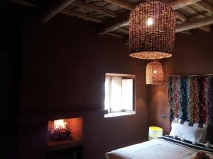 a bedroom with a bed and a window and a chandelier at Dar Isselday in Tisselday +55 photos