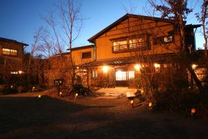a house with lights in front of it at night at Ryokan Kono-Yu in Minamioguni