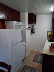 a small kitchen with a white refrigerator and cabinets at 3864 Walsh Street Apartment in Jacksonville