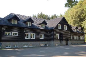 a large wooden house with a gambrel roof at Hotel Stará Ameryka in Jablunkov