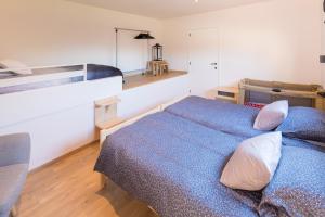Un dormitorio con una cama azul con almohadas. en Vakantiewoning De Gulden Sleutels, en Kruibeke