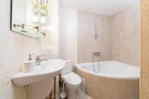 a bathroom with a sink and a toilet and a tub at Sozopol Seaside Apartment in Sozopol