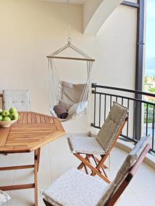 a hammock hanging from a balcony with a table and chairs at Lila apartmani in Baošići