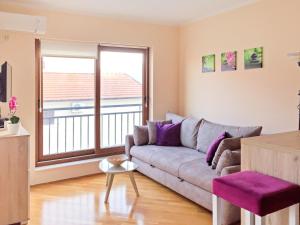 a living room with a couch and a large window at Lila apartmani in Baošići