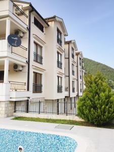 an apartment building with a swimming pool in front of it at Lila apartmani in Baošići