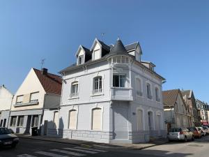 ein weißes Gebäude am Straßenrand in der Unterkunft Relais Vacances à la Mer in Berck-sur-Mer