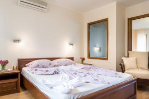 a bedroom with a bed with pink sheets and a mirror at Sozopol Seaside Villa in Sozopol