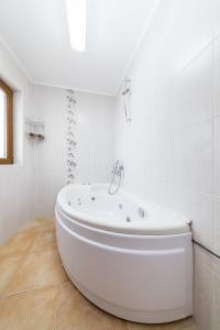 a white bathroom with a tub in a room at Sozopol Seaside Villa in Sozopol +9 photos