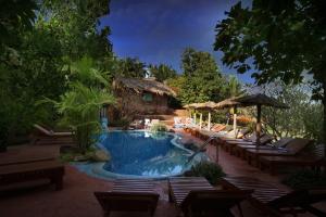 una piscina con tumbonas y un complejo en Pride Sun Village Resort & Spa en Baga
