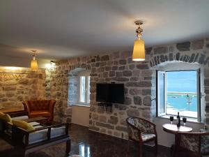 a living room with a stone wall at Apartmani Armonia in Perast