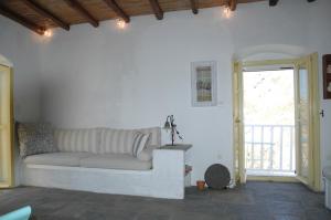 a white living room with a couch and a door at Open Space House at the Castle of Chora, Serifos in Serifos Chora