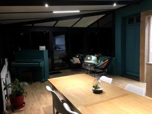 a living room with a table and a piano at Le Clos de la Commanderie in Amboise