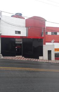 a red and white building on the side of a street at HOTEL KISS - TABOÃO DA SERRA in Taboão da Serra