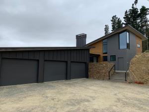 a house with two garage doors in front of it at Secluded Getaway in Oamaru