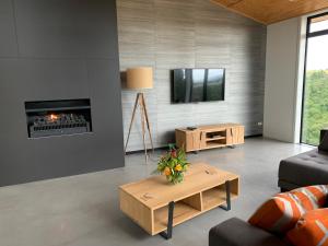 a living room with a fireplace and a tv at Secluded Getaway in Oamaru