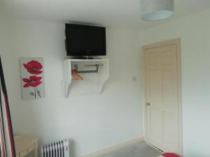 a white room with a television and a door at Slaney House B&B in Lahinch