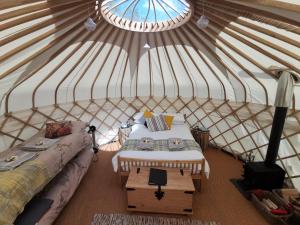 a room with two beds and a table in a yurt at Syke Farm Campsite - Yurt's in Buttermere