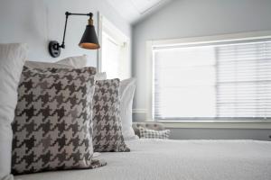 a bedroom with a bed with pillows and a window at Hounds Tooth Inn in Oakhurst