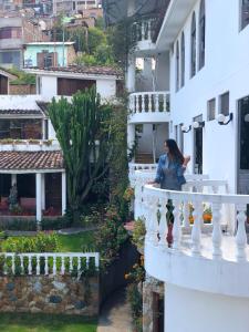 a woman sitting on a balcony of a building at La Mansion Casa Hotel in Andahuaylas