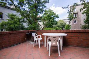 a patio with a table and chairs next to a brick wall at Student-House Kazimierzowska in Warsaw