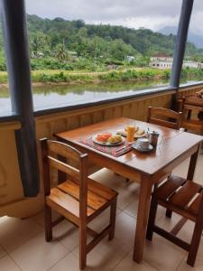 einen Tisch mit einem Teller Essen und einem Fenster in der Unterkunft Residencial Mira Rio in Santo António