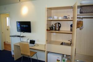 a room with a desk with a computer and a monitor at Abbots Hamilton – Hotel and Conference Centre in Hamilton