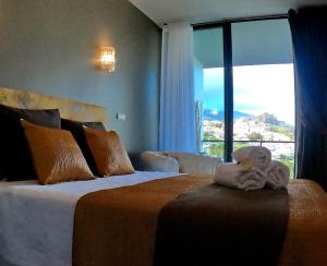 una camera da letto con un letto grande con una grande finestra di View Apartament SAO JOAO a Funchal Altre 31 foto