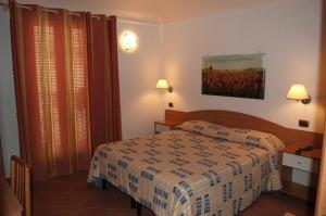 a hotel room with a bed and a painting on the wall at Il Rustico in Grammichele
