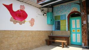 een gebouw met een schilderij van een kip aan de muur bij Miao Home in Fanlu